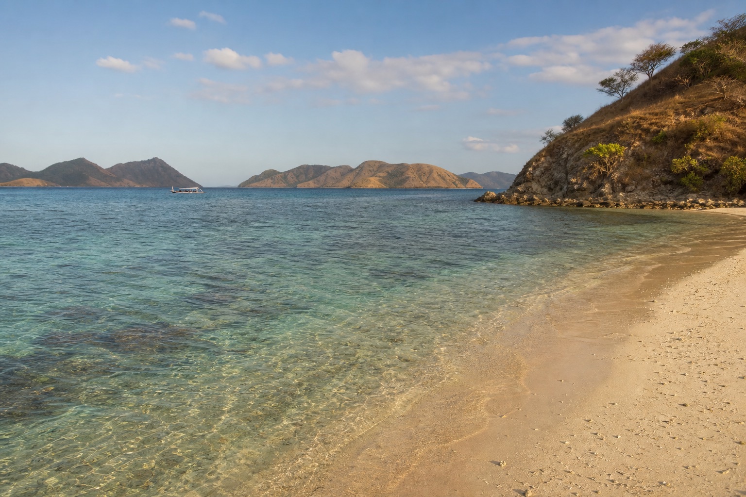 Visual editorial garis pantai Pulau Kanawa pada sore hari